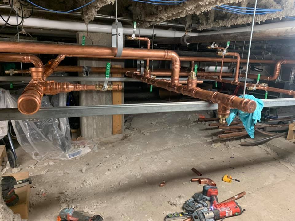 Un tas de tuyaux en cuivre pendent du plafond d'une pièce.