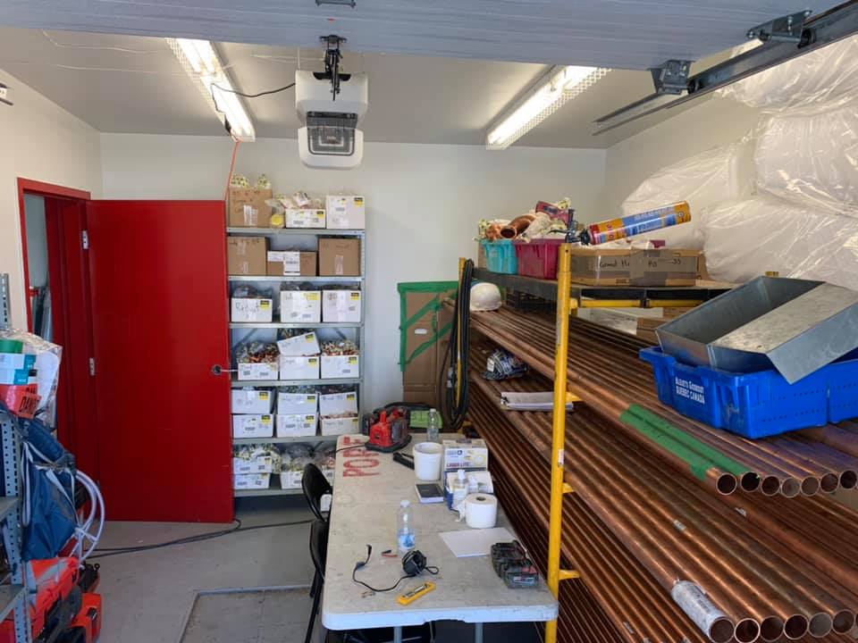 Une pièce avec une table et des étagères remplies de boîtes et de tuyaux