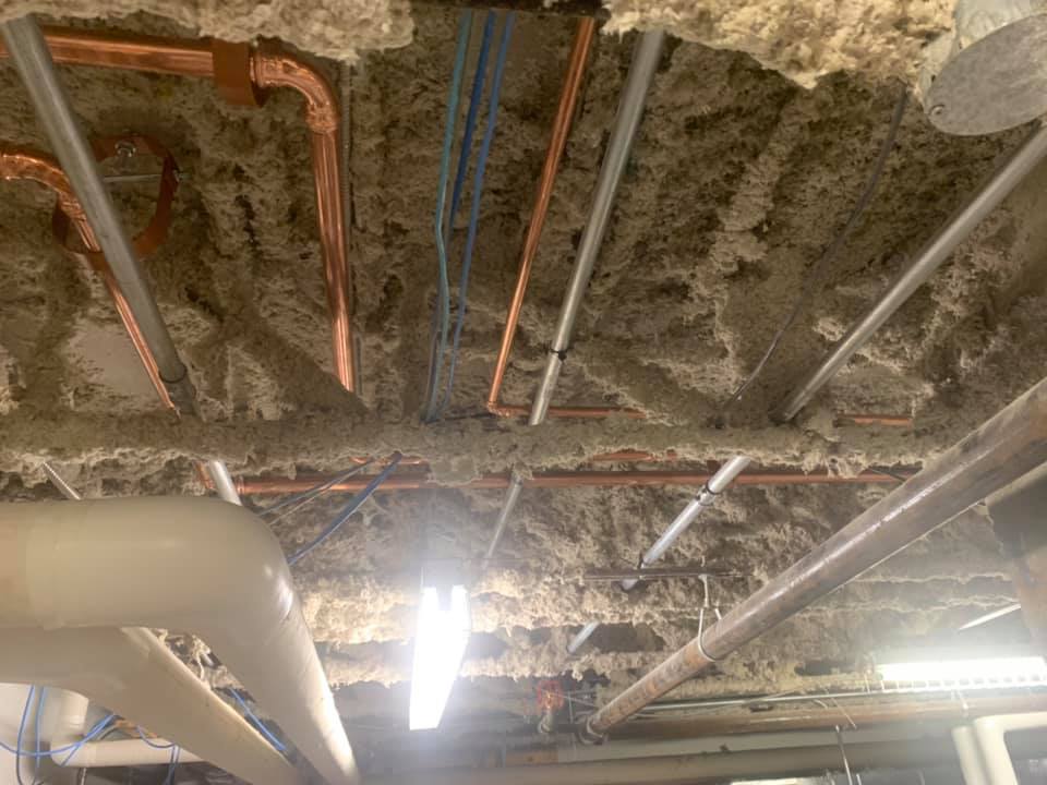 Un tas de tuyaux pendent du plafond d'un bâtiment.