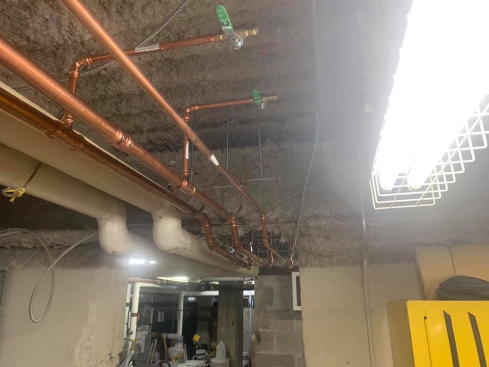 Une pièce avec beaucoup de tuyaux suspendus au plafond.