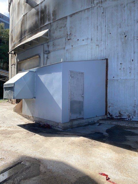 Un petit bâtiment blanc avec une porte sur le côté