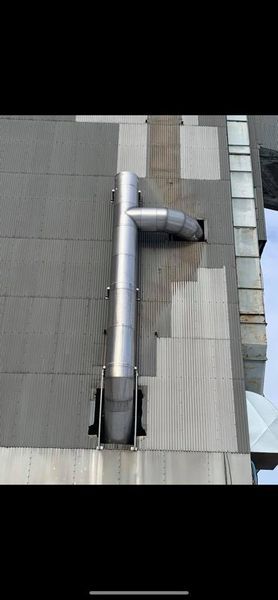 Un tuyau métallique est suspendu au côté d'un bâtiment.