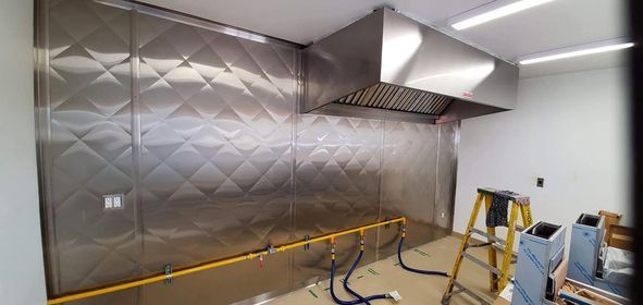 Une cuisine avec un mur en acier inoxydable et une échelle.