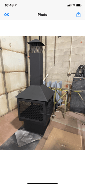 Une cheminée noire se trouve dans une pièce à côté d'une porte de garage.