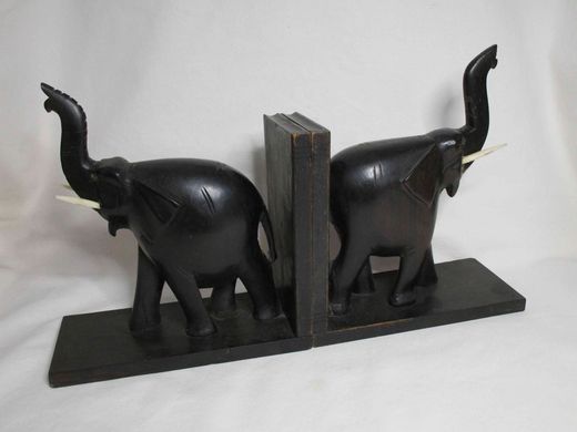 A pair of wooden elephant book ends with raised trunks