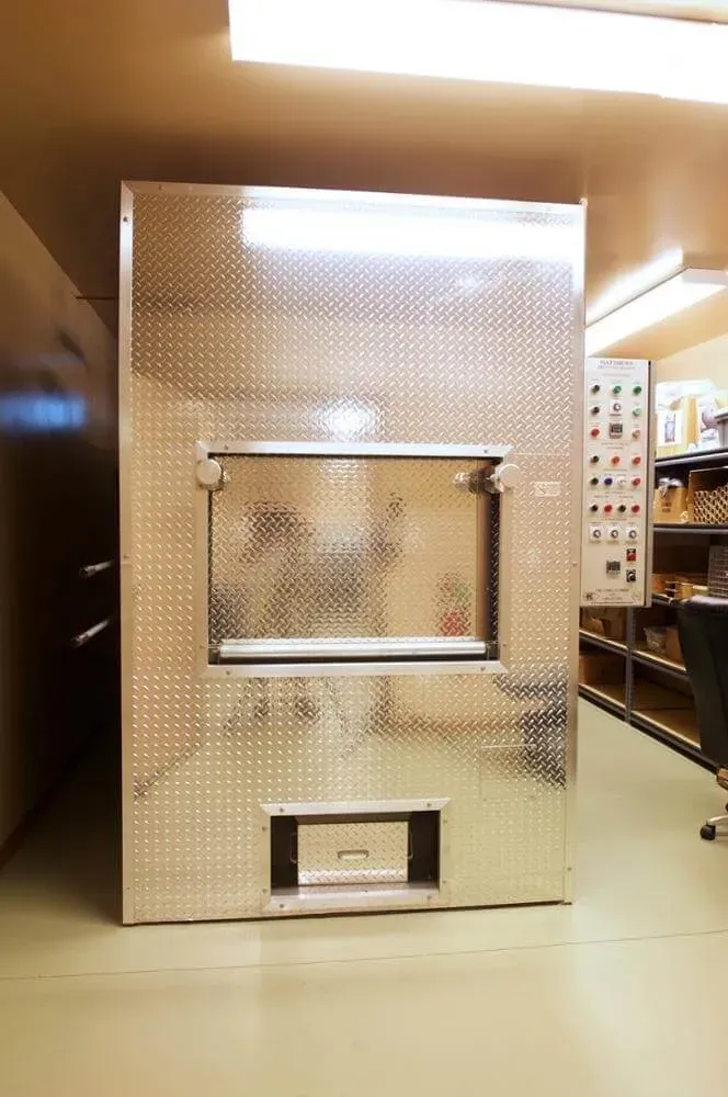 A metallic display booth with a glass front in a bright indoor showroom