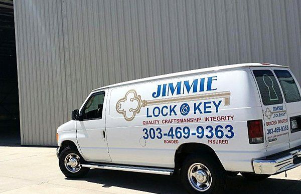 White locksmith van with “JIMMIE LOCK & KEY” signage parked outside a warehouse