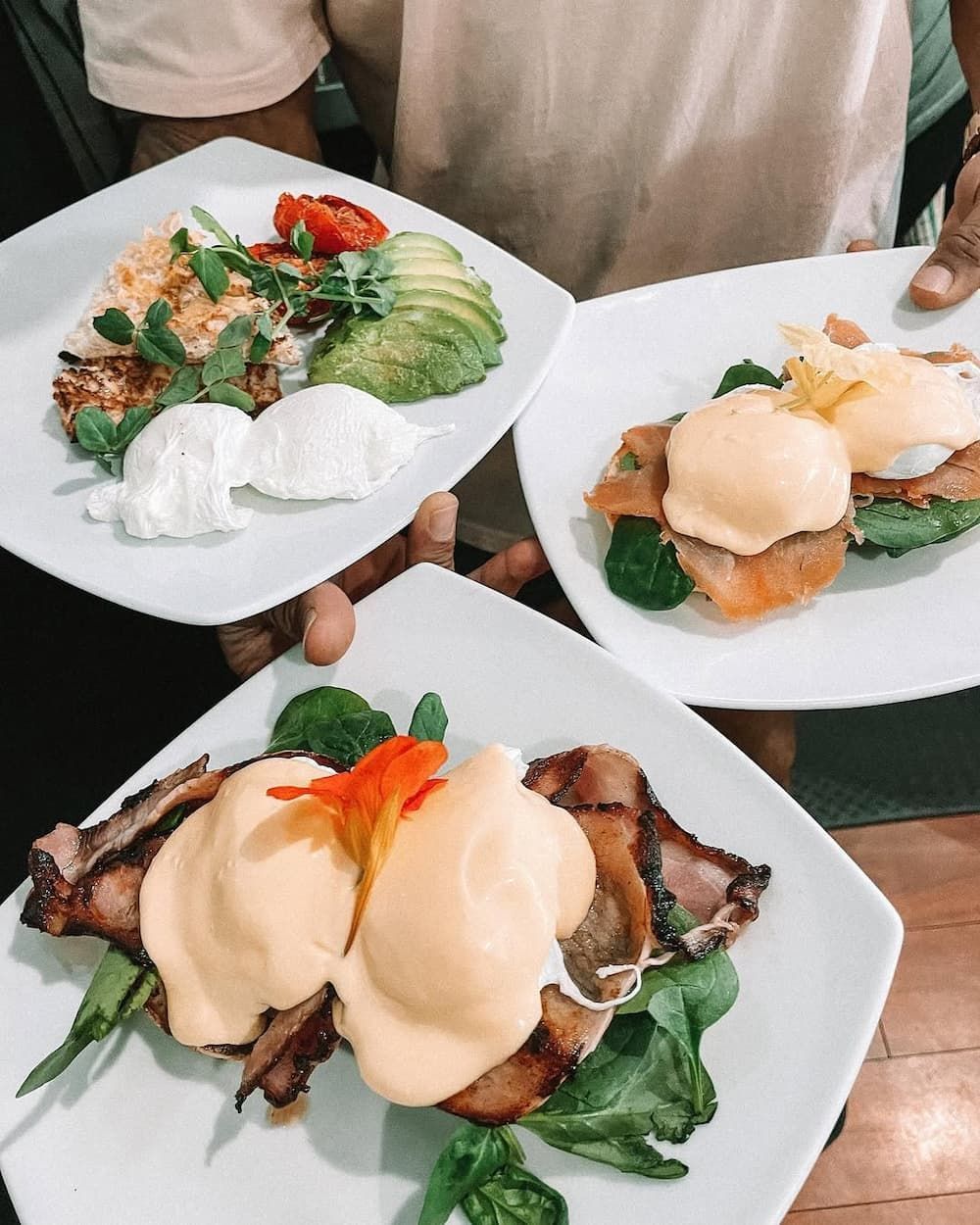 A Person is Holding Three Plates of Food in Their Hands — Swish Cafe in Ballina, NSW