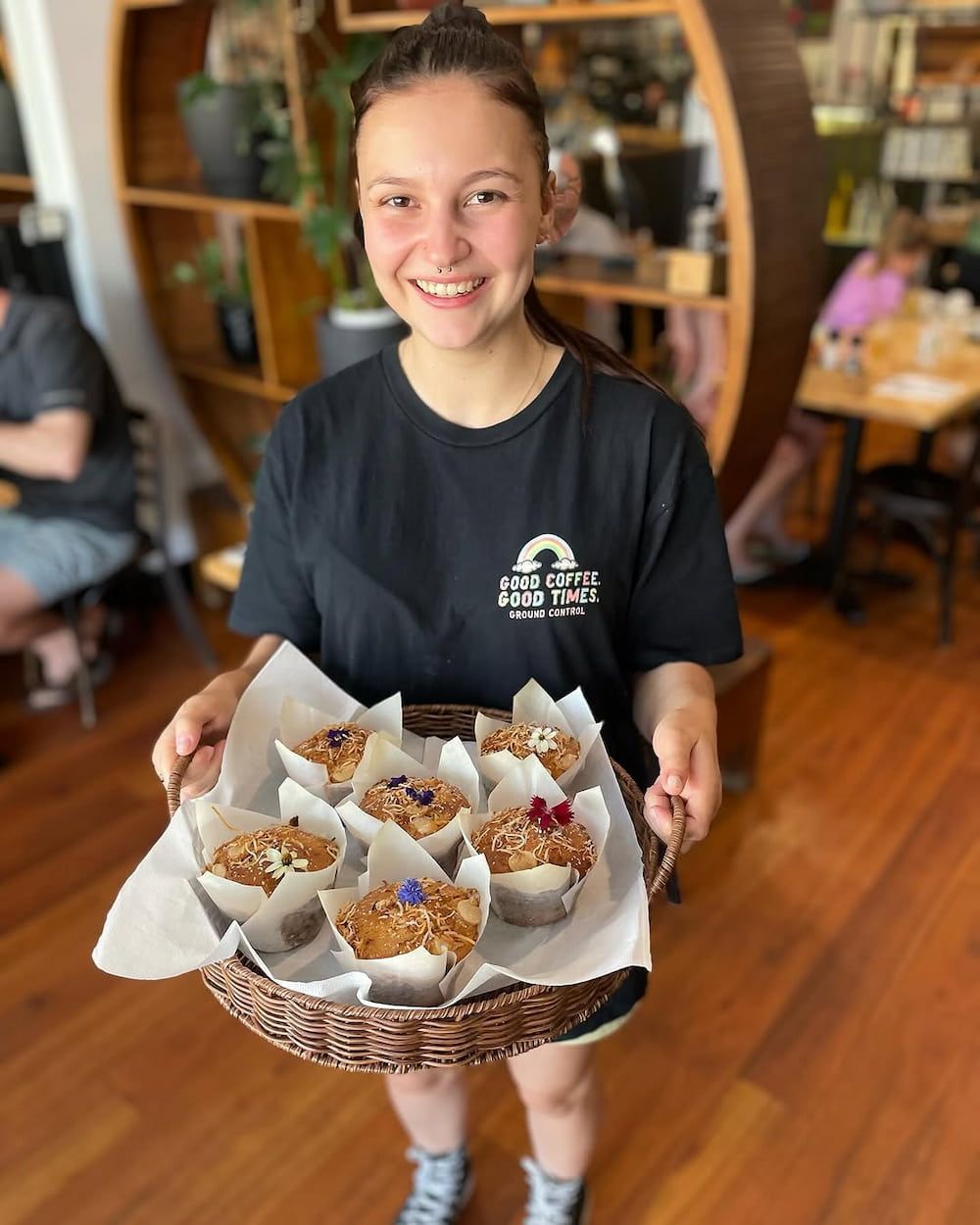 A Woman is Holding a Basket of Cupcakes in a Restaurant — Swish Cafe in Ballina, NSW