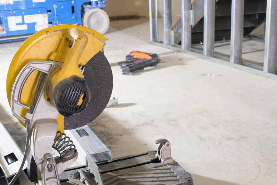 Construction tools including a circular saw and framing materials, used for drywall installation and repair services