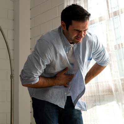 A man feeling upper abdominal pain from Gastritis