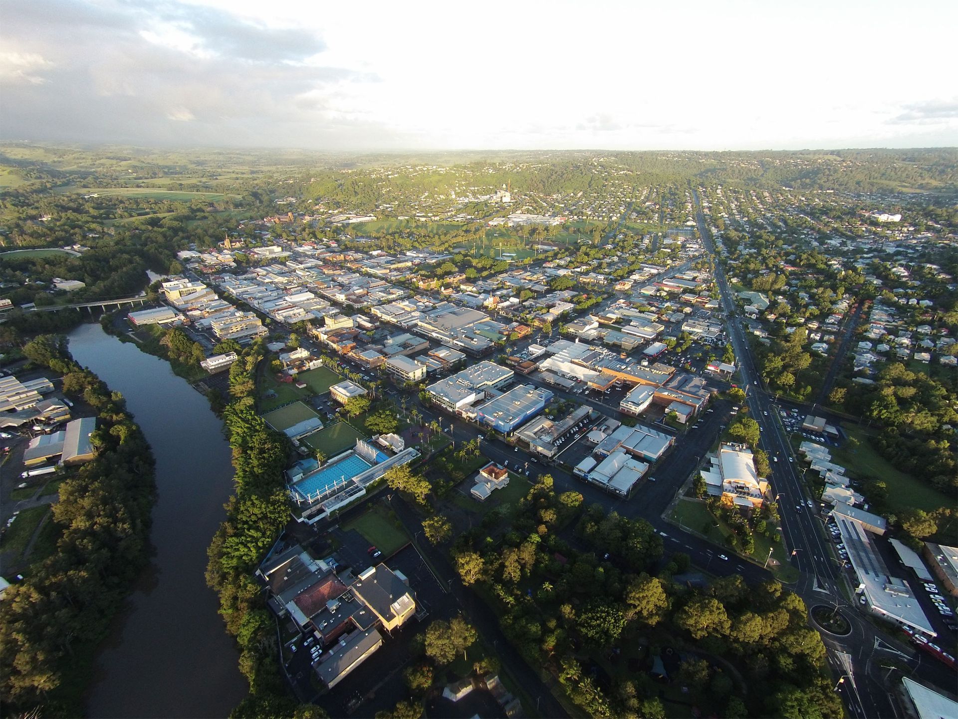An aerial view of a city surrounded by trees and a river.