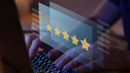 Hands typing on a laptop with a translucent 5-star rating overlay.