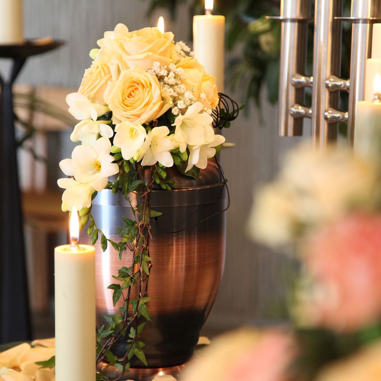 A vase filled with flowers and candles on a table