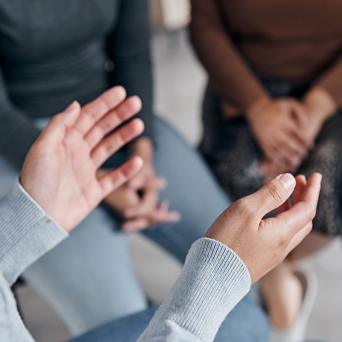 A group of people are sitting in a circle talking to each other.
