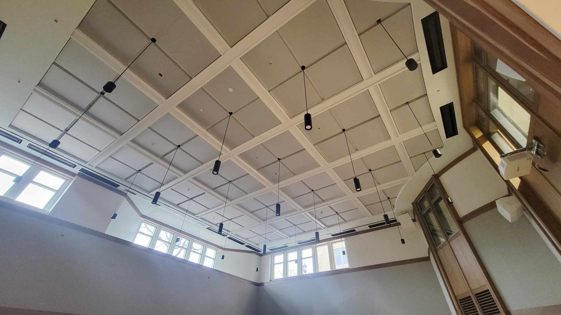 Looking up at the ceiling of a large room with lots of windows