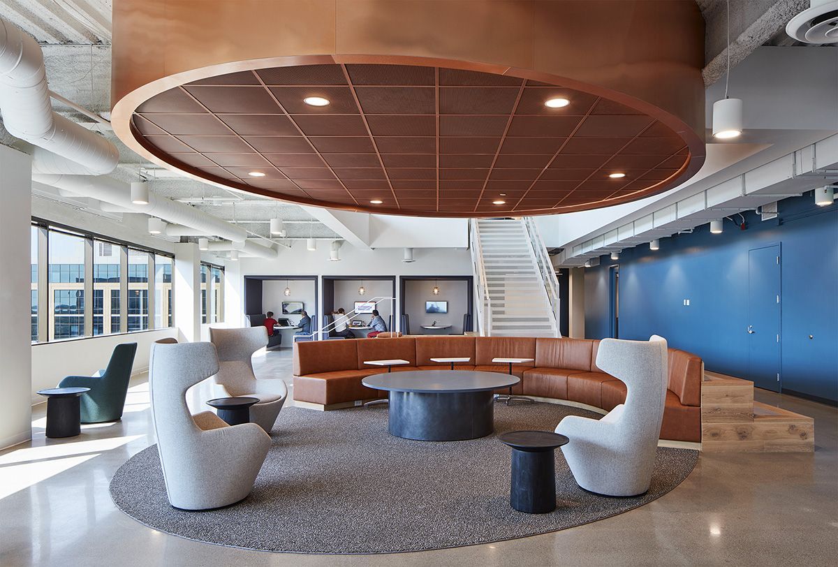 A living room with a circular ceiling , a couch , chairs and tables.