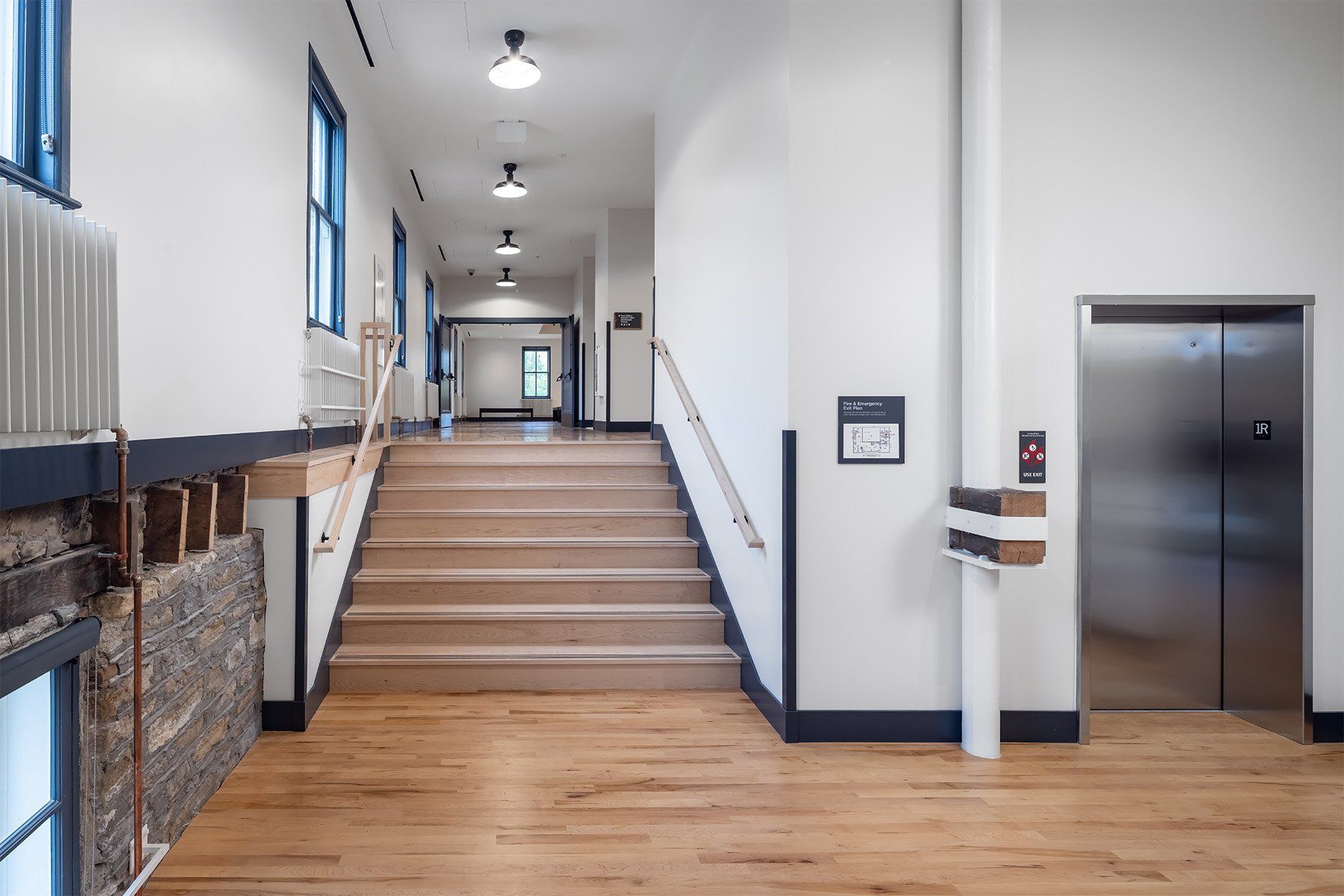 A hallway with stairs and an elevator in a building