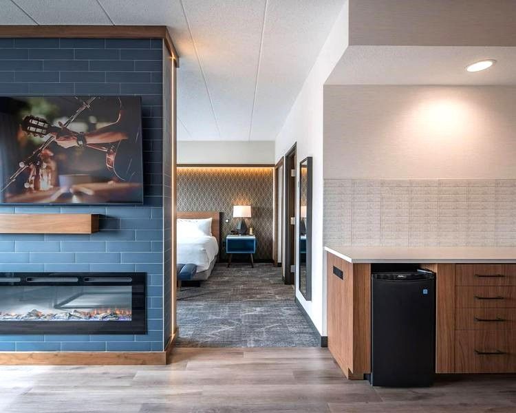 A hotel room with a fireplace and a bed.