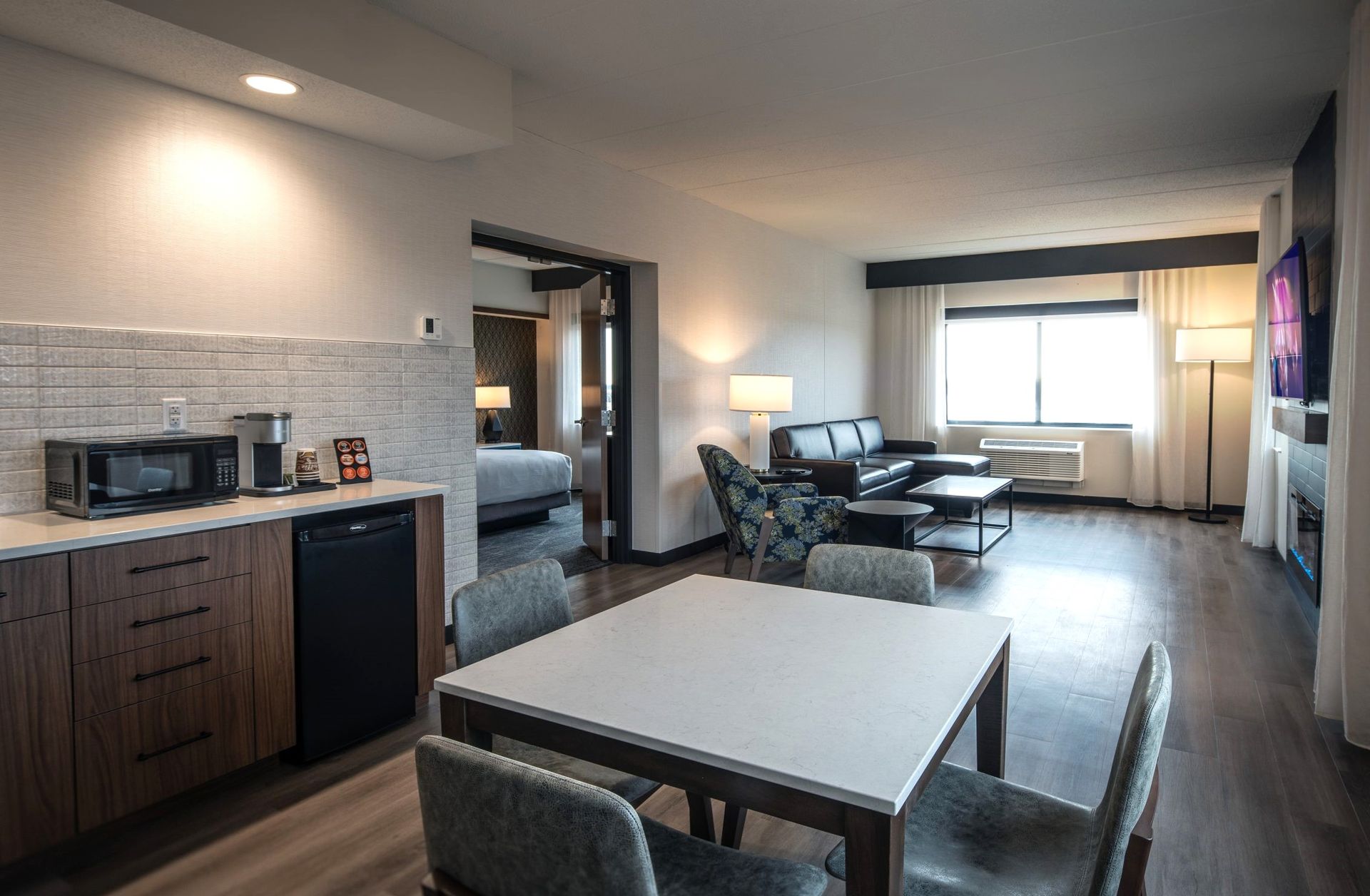 A hotel room with a table and chairs in it.