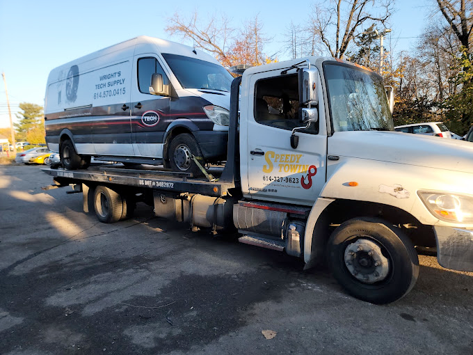 A tow truck with a van on the back of it