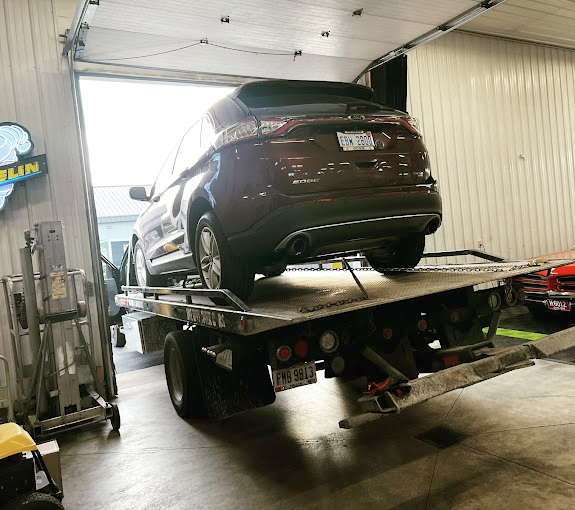 A car is being towed by a tow truck in a garage.