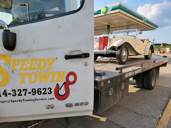 A speedy towing truck is carrying a golf cart