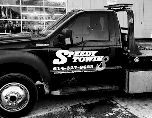 A black and white photo of a speedy towing truck
