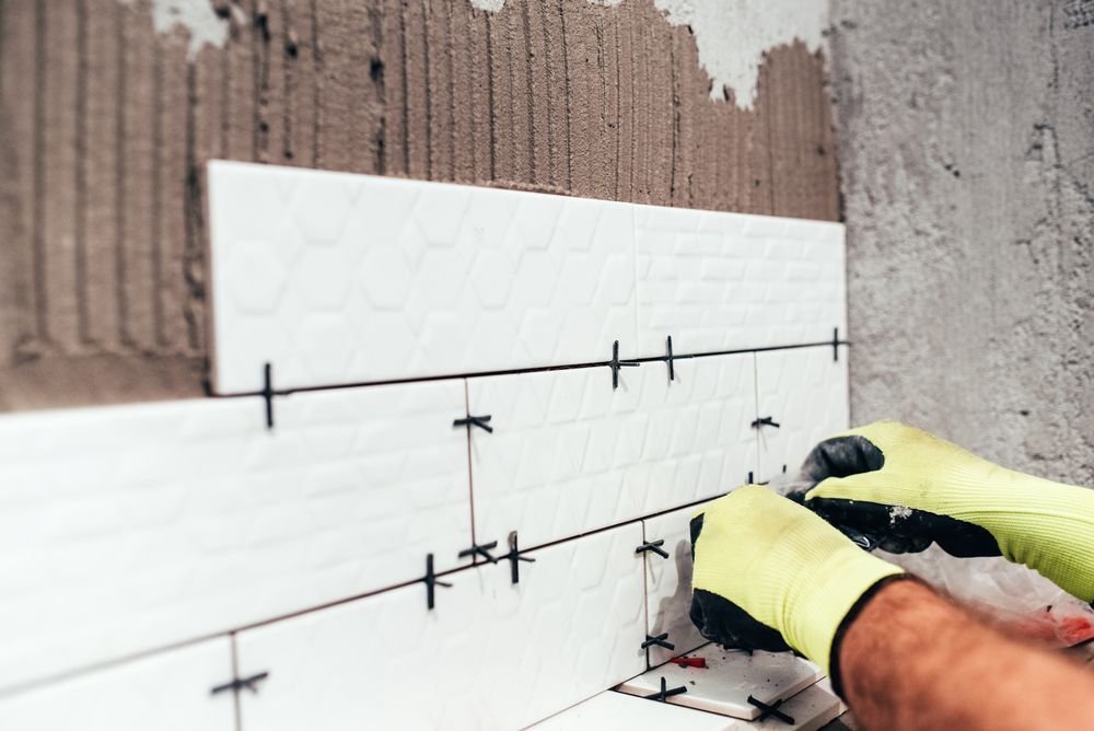 Man installing tiles inside the bathroom Renovating a Bathroom in South Central, PA to Elevate Your Space