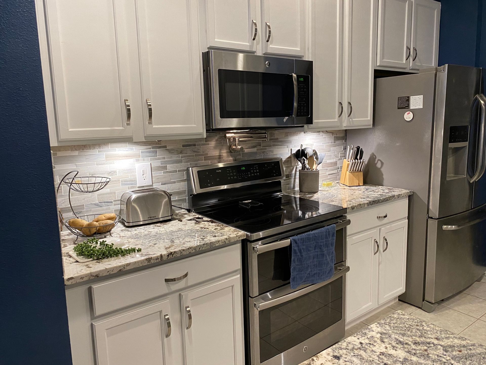 Kitchen with white cabinets, stainless steel appliances, and a granite countertop.