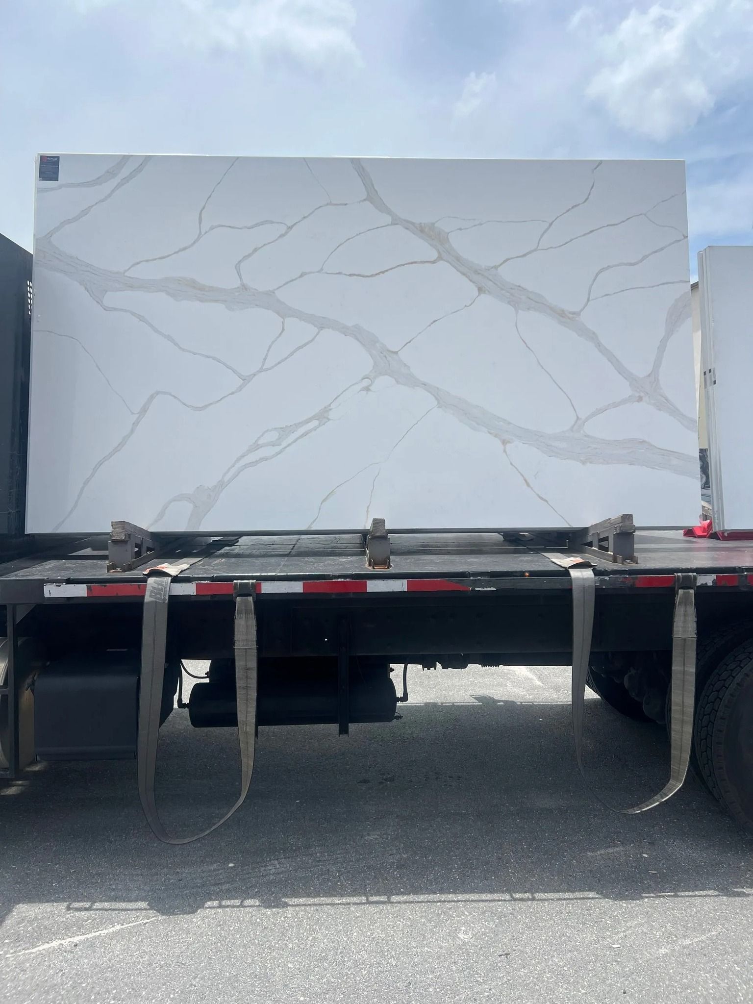 White countertop slab with gray veining secured on a truck bed.