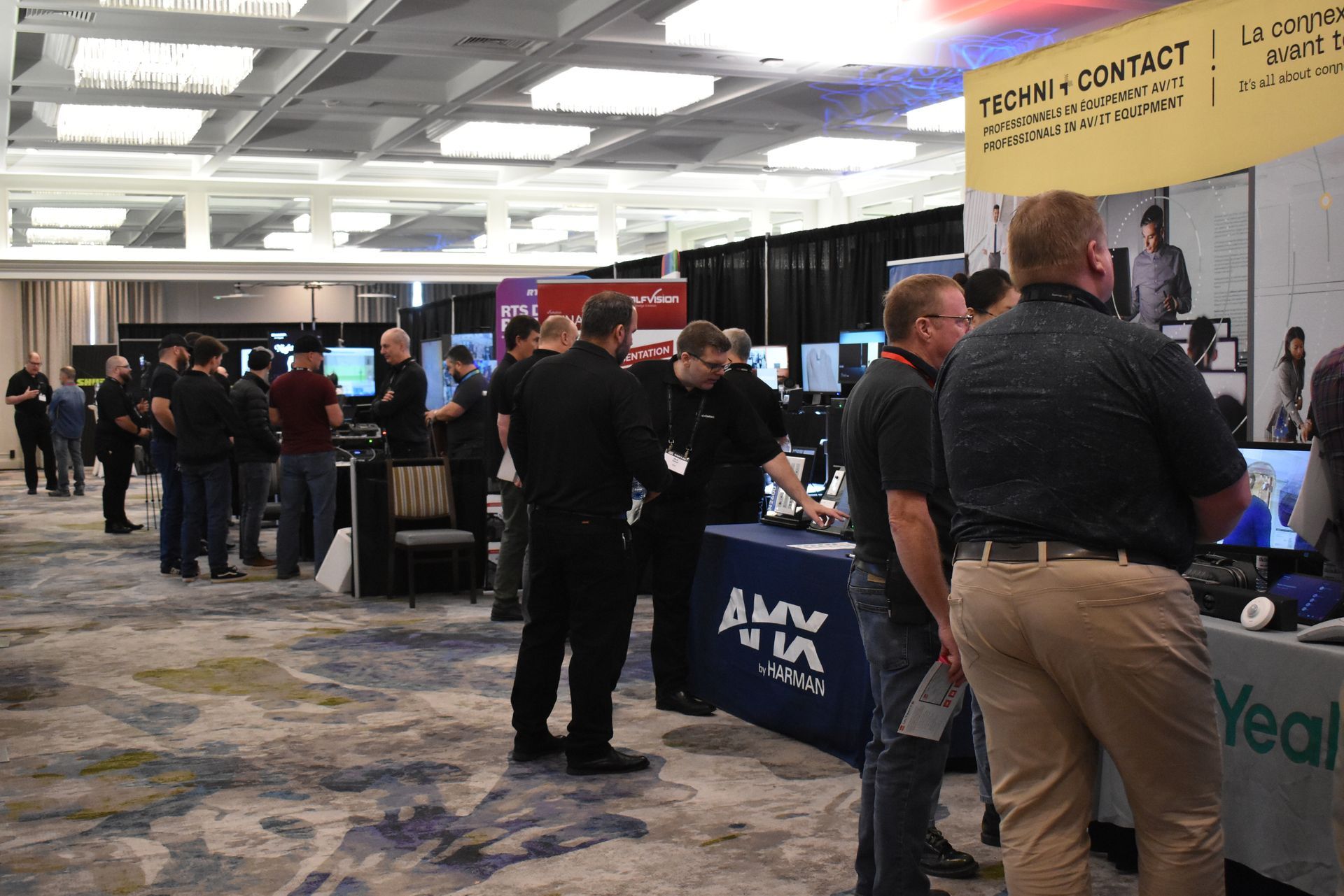 People browsing booths at a trade show in a large conference hall