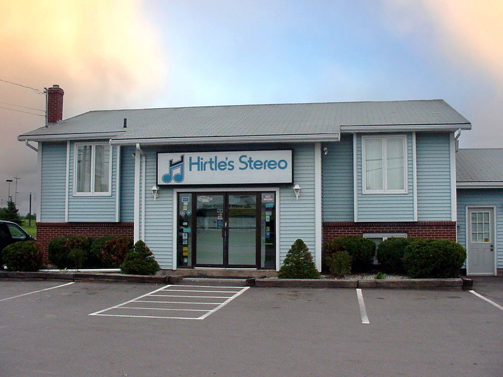 Hartles Stereo storefront in a small parking lot at dusk