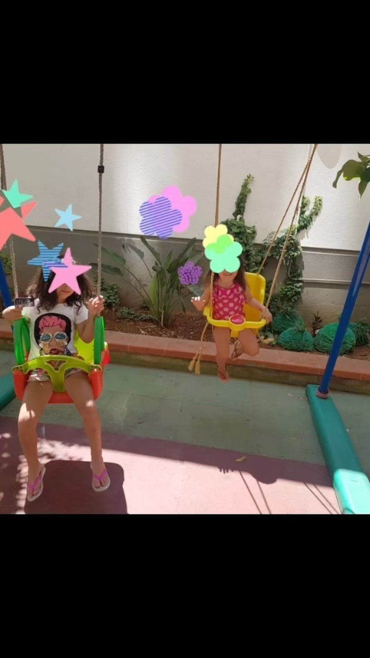 Due bambini sulle altalene in un cortile.