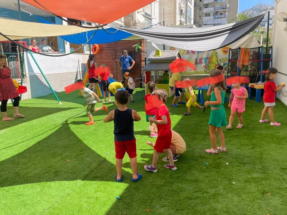 Bambini che giocano all'aperto sotto teli ombreggianti.