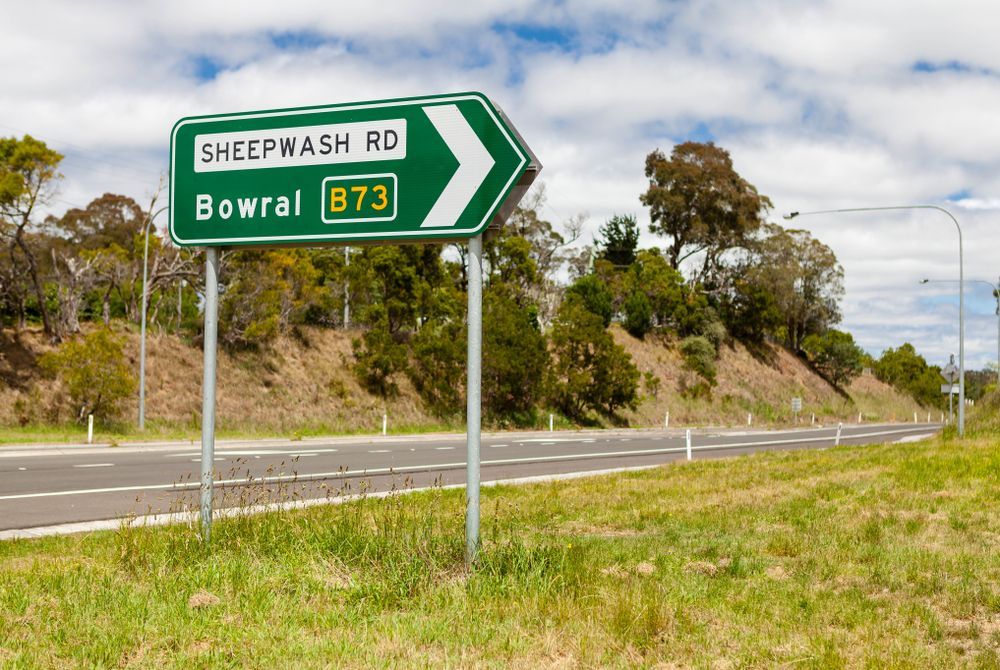 A Green Sign On The Side Of A Road That Says Sheepwash Rd Bowral — About Time Plumbing & Civil Construction in Bowral, NSW