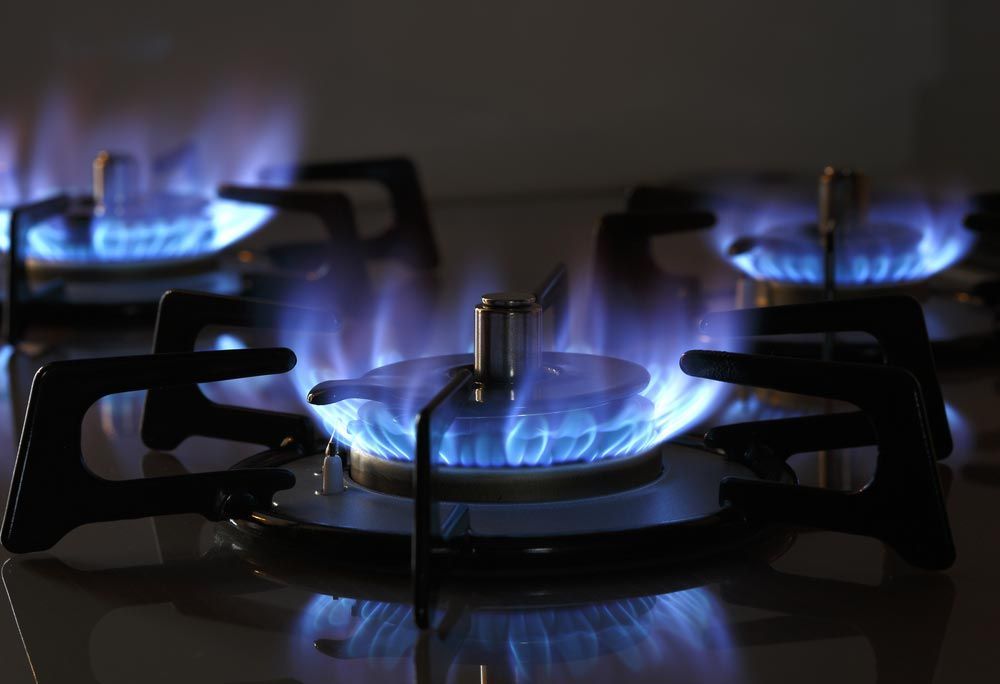 A Close Up Of A Gas Stove With Blue Flames Coming Out Of It — About Time Plumbing & Civil Construction in Moss Vale, NSW
