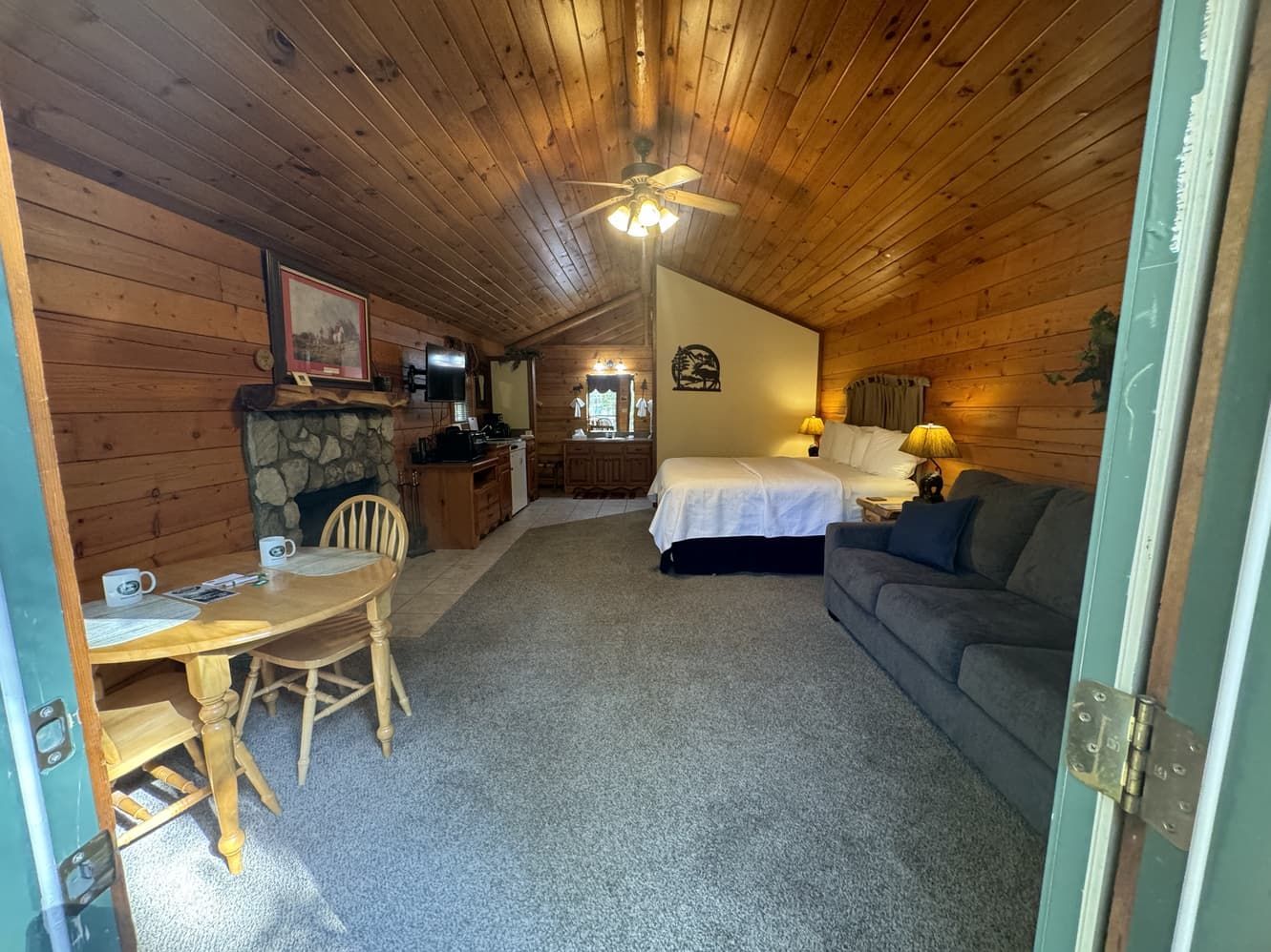 A room with a bed , couch , table and chairs in it.