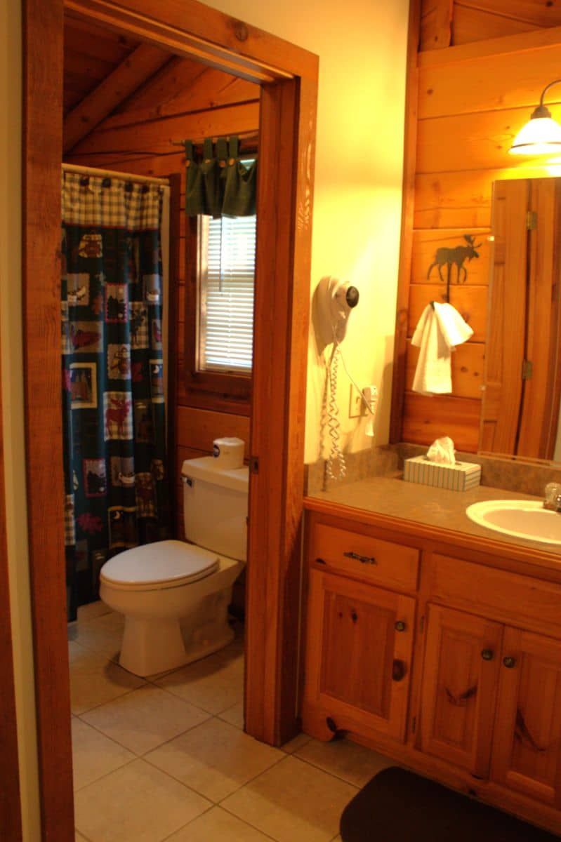 A bathroom with a toilet , sink and mirror