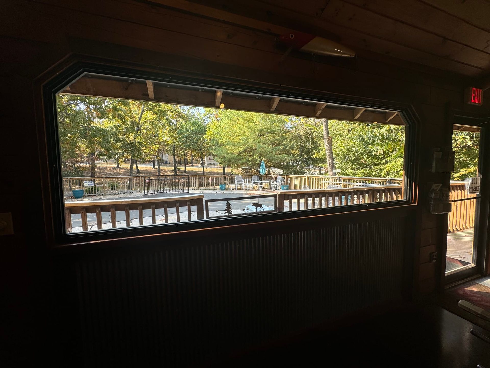 A large window with a view of a deck and trees.