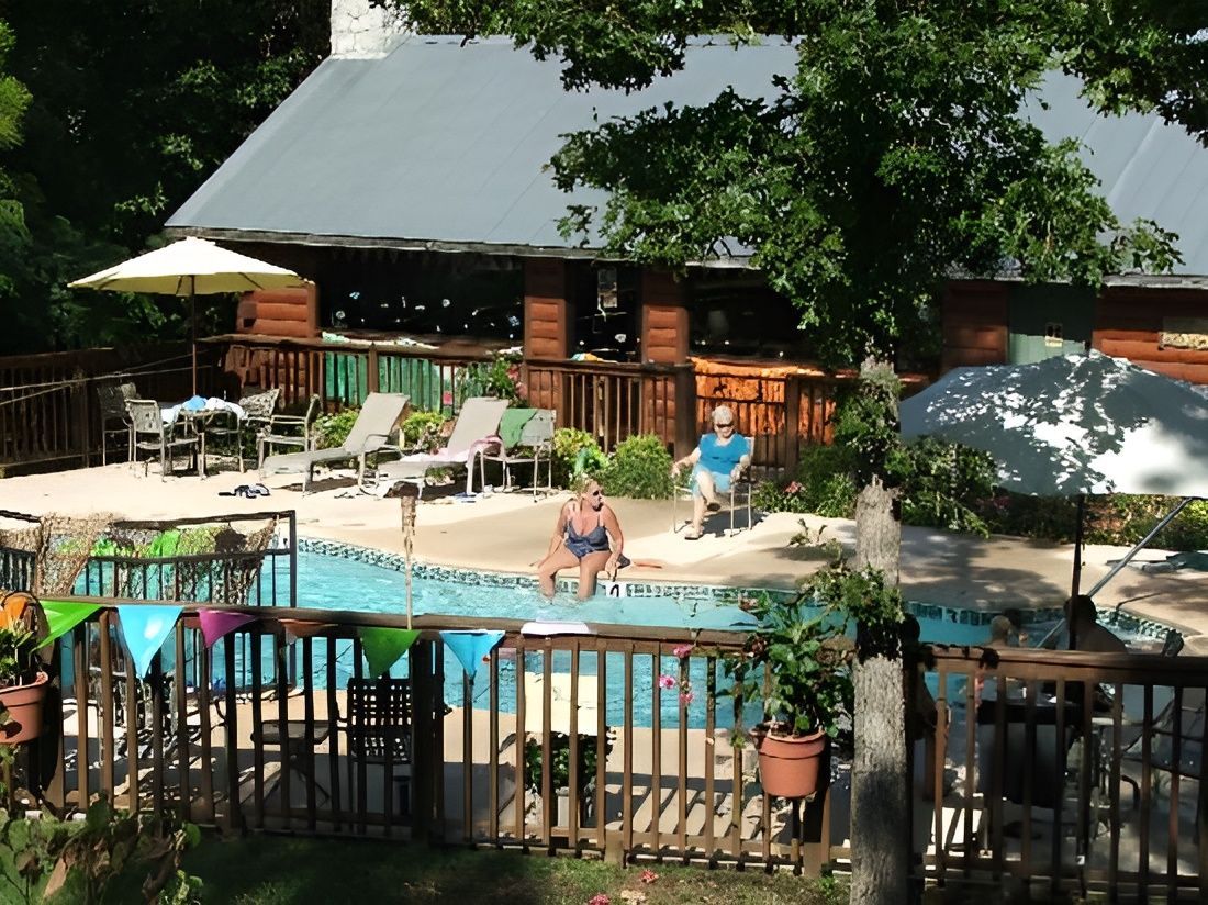 A woman sits in a chair near a swimming pool