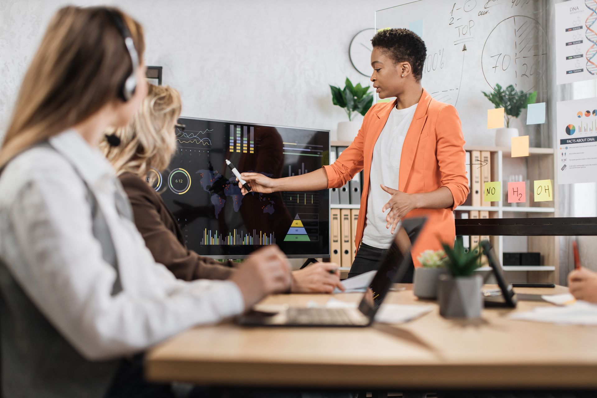 Person presenting a design on a monitor in a bright office meeting room