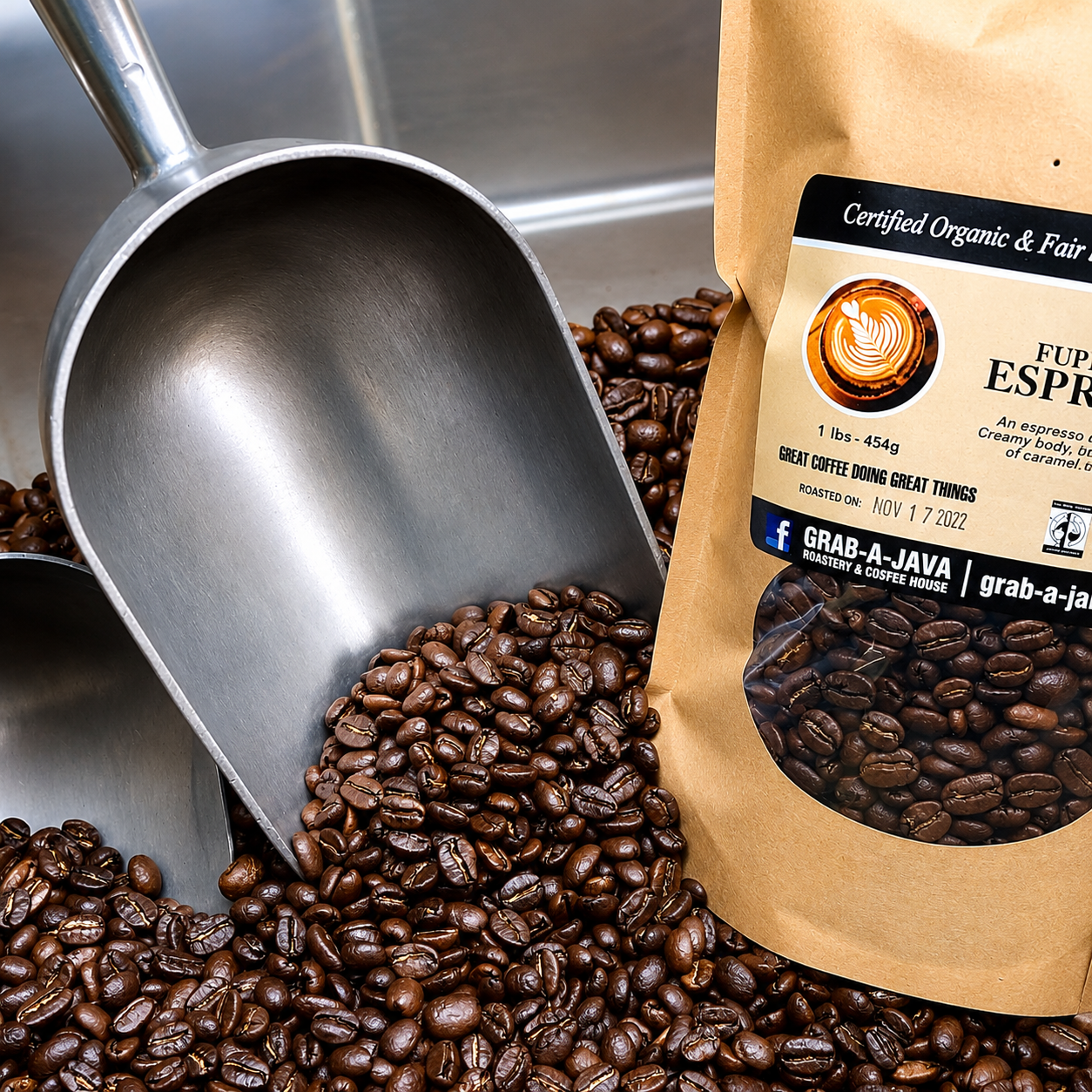 Coffee beans spilling from a metal scoop beside a brown coffee bag with a label.