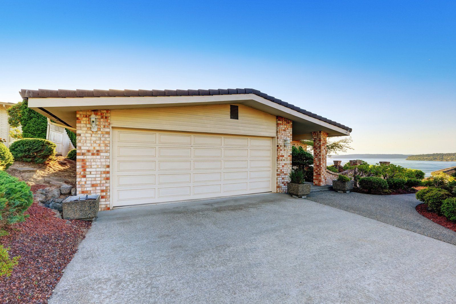 a concrete driveway leading to a house with grass on the side