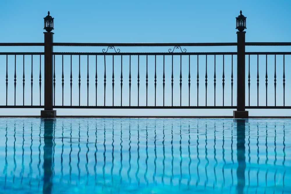 A Fence Surrounds a Swimming Pool With a View of the Ocean — AM & JD Contracting In Muswellbrook, NSW