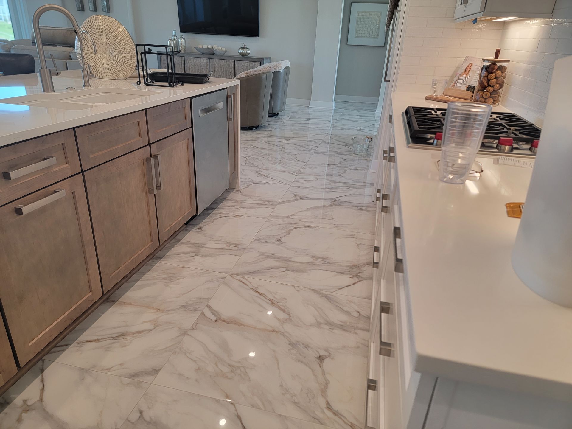 Kitchen with marble floors, light wood cabinets, and white countertops.