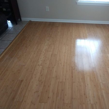 Bamboo flooring in a room with a window. Sunlight reflects on the floor.