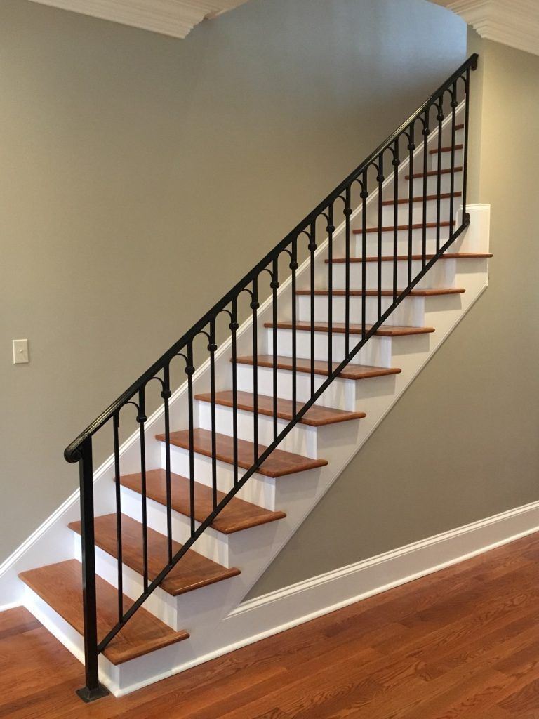 A staircase with wooden steps and a black railing