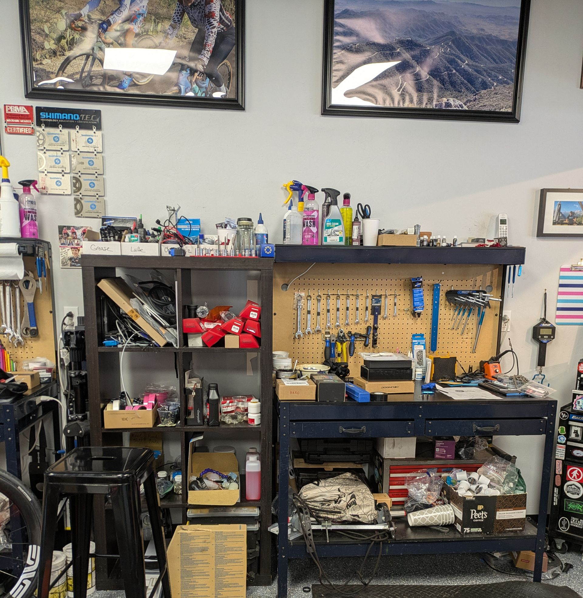 Bike repair shop interior with tools, parts, and workbenches.