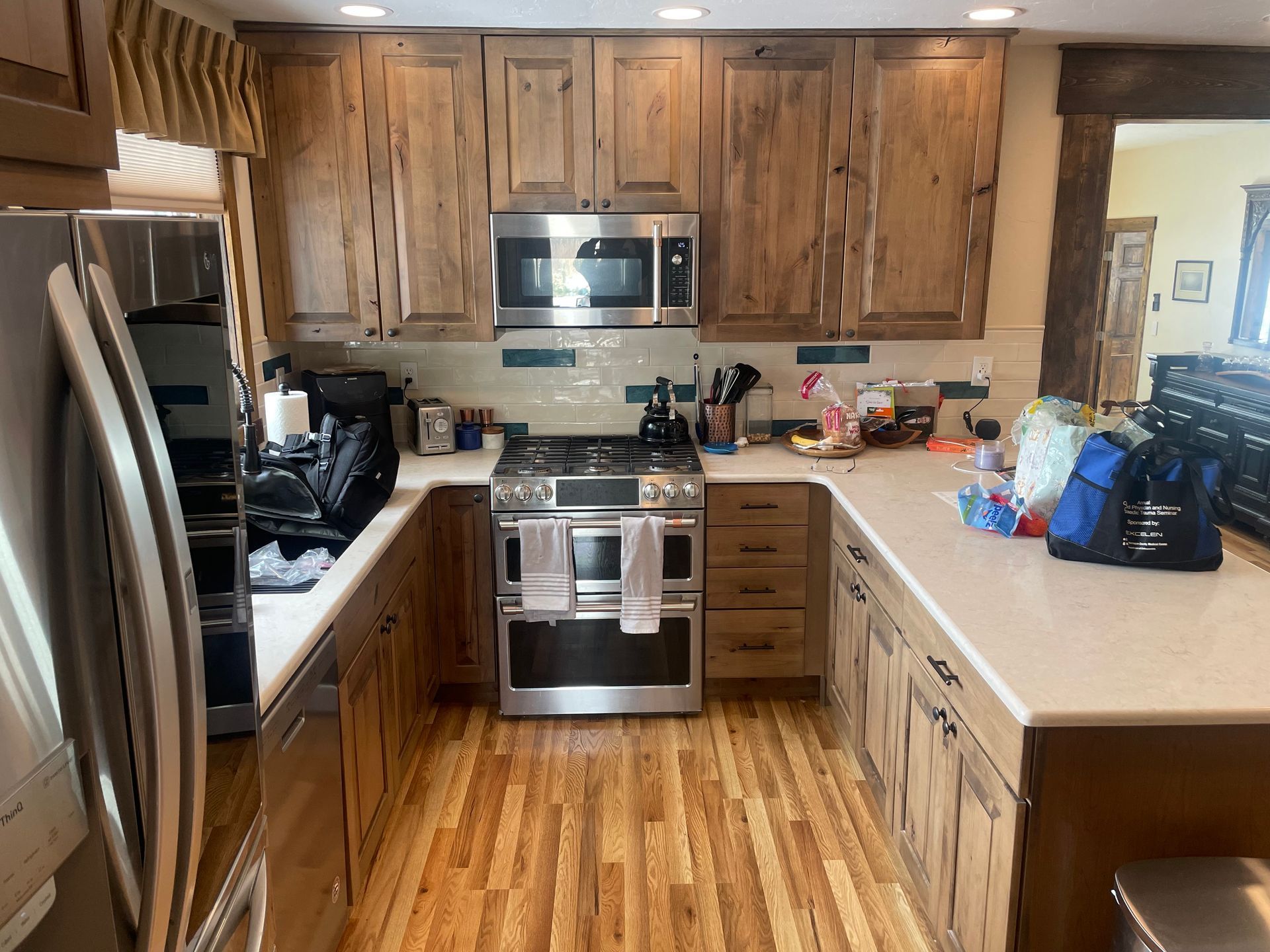 Modern kitchen with wooden cabinets, stainless steel appliances, and white countertops